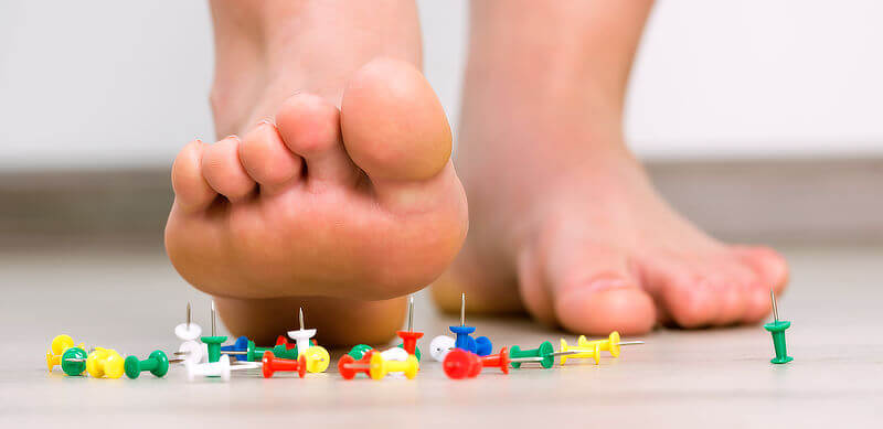 Person stepping on pins